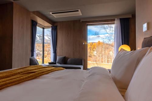 a bedroom with a large bed and a large window at The 1898 Niseko in Kutchan
