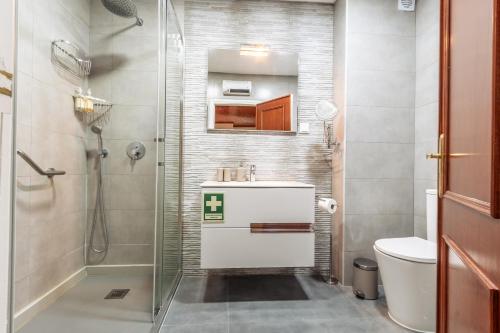 a bathroom with a shower and a sink and a toilet at Ericeira Beach Apartment in Ericeira