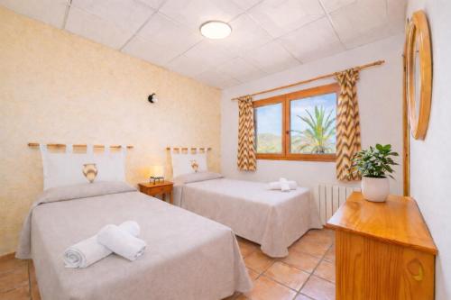 a bedroom with two beds and a window at Ca na Lluny in Artá