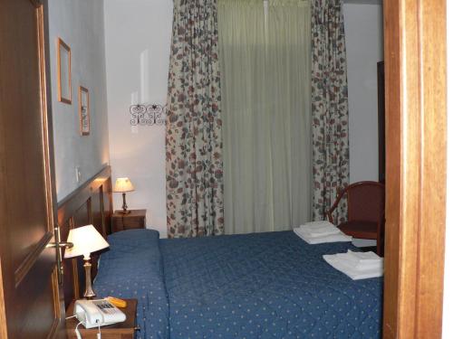 a hotel room with a blue bed and a chair at Hotel La Quiete in Bardonecchia