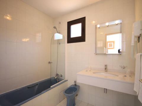 une salle de bain avec un lavabo, des toilettes et une baignoire dans l'établissement Hôtel Le Romantique, à Porto Ota