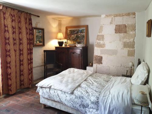 a bedroom with a bed and a brick wall at Domaine de La Siaule in Saint-Germain-dʼAunay