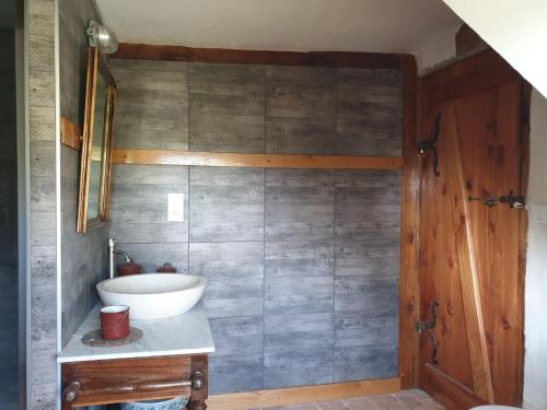 a bathroom with a white sink and a wooden door at Domaine de La Siaule in Saint-Germain-dʼAunay