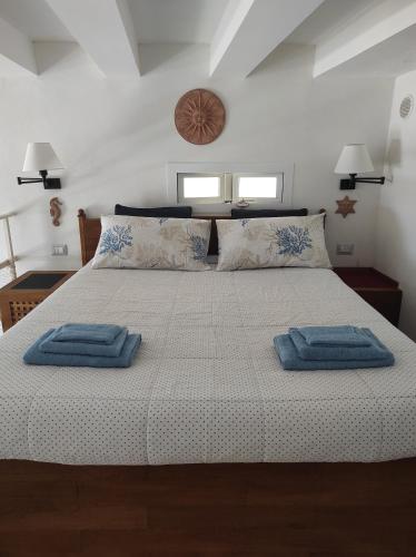 a bedroom with a large bed with two towels on it at La Tana in Formia