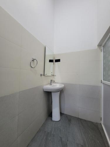 a white bathroom with a sink and a mirror at The Secret Place Hotel & Resort in Kandy