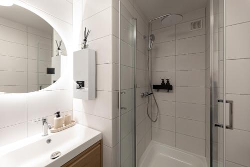 a white bathroom with a shower and a sink at Studio 4 in Bad Schallerbach