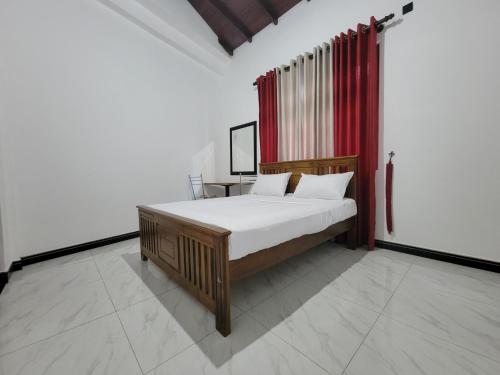 a bedroom with a bed and a red curtain at The Secret Place Hotel & Resort in Kandy