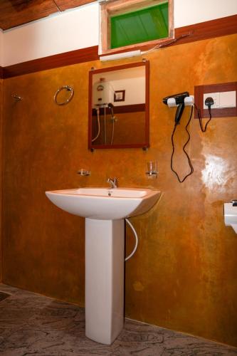 a bathroom with a white sink and a mirror at Comfort Treehouse Pidurangala in Dambulla