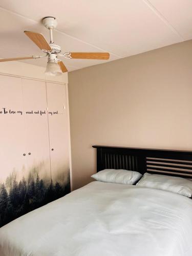 a bedroom with a bed with a ceiling fan at Honeypot Ridge 29 in Honeydew