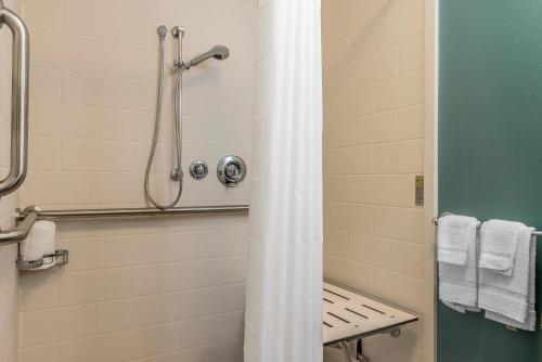 a bathroom with a shower with a shower curtain at Sleep Inn & Suites Cumberland in Cumberland