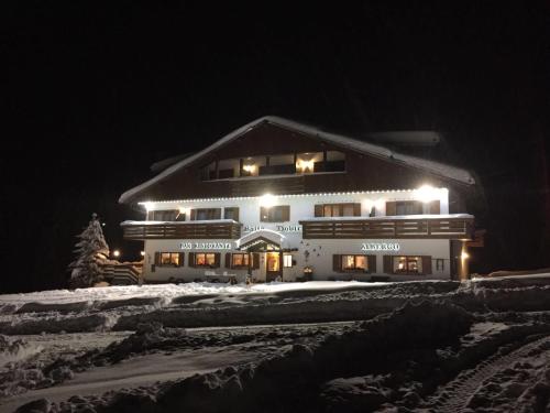 a large building in the snow at night at Hotel & Ristorante Baita Dovich in Malga Ciapela