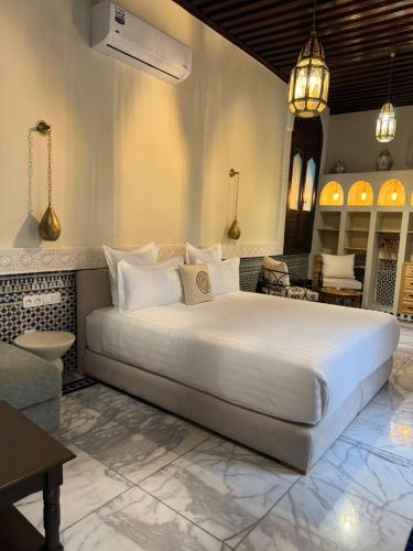 a bedroom with a large white bed in a room at Riad Citronnier & Spa in Fez