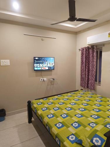 a bedroom with a bed and a flat screen tv at Hotel Homestay-Bhimavaram in Bhīmavaram