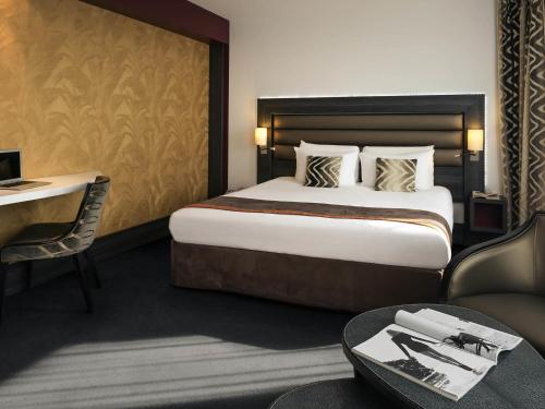a hotel room with a large bed and a table at Mercure Lyon Centre - Gare Part Dieu in Lyon