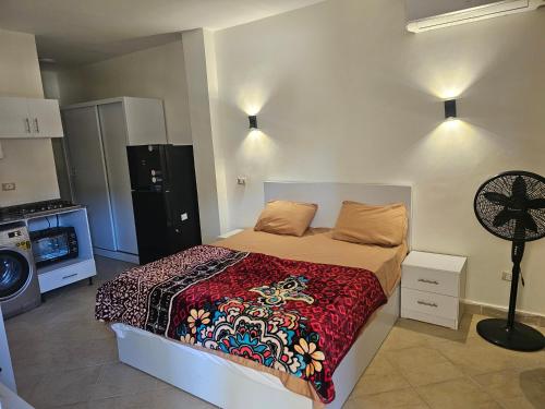 a bedroom with a bed and a fan at Ground floor Garden & Pool & Beach Studio in Sharm El Sheikh