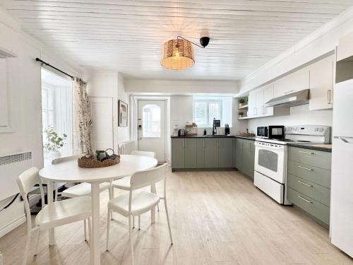 a kitchen with a white table and chairs in a room at Le petit d'Antan Parking 10 min from the center in Quebec City