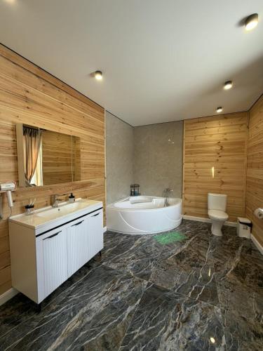a bathroom with two sinks and a tub and a toilet at Forest Club Burabay in Zhezdi