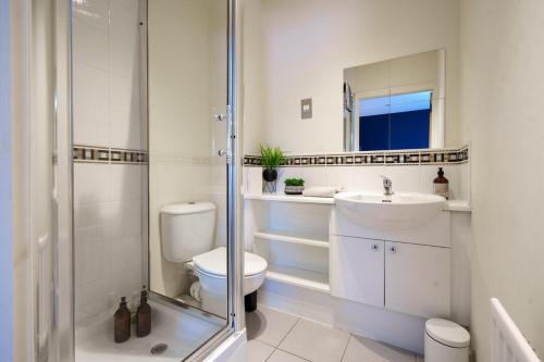 a bathroom with a toilet and a sink and a shower at 5 Bed Finnieston SkyHigh Duplex with Parking in Glasgow