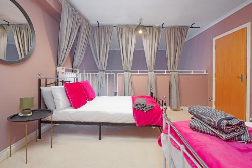 a bedroom with a bed with pink and purple walls at 5 Bed Finnieston SkyHigh Duplex with Parking in Glasgow
