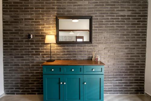 a bathroom with a blue cabinet and a mirror at Mikio Guest House in Kalabaka