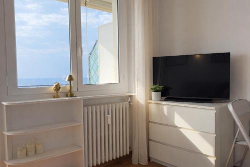 a living room with a television and a window at La Casa Di Gianni - Vista Mare in Ospedaletti