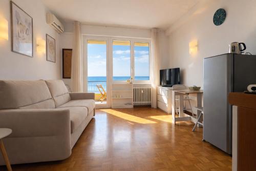 a living room with a couch and a table and a television at La Casa Di Gianni - Vista Mare in Ospedaletti