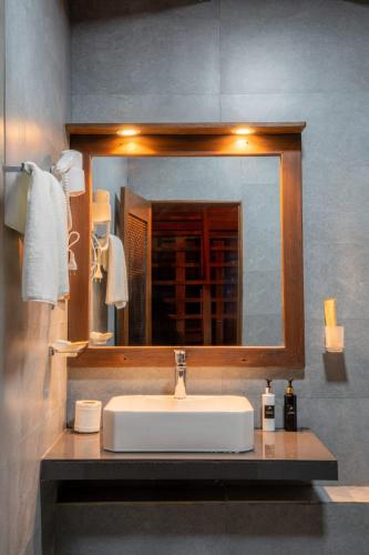 a bathroom with a sink and a mirror at Monsoon Cabana Ella in Ella
