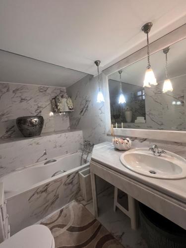 a bathroom with a sink and a tub and a mirror at Stone house Anogeia in Anogeia