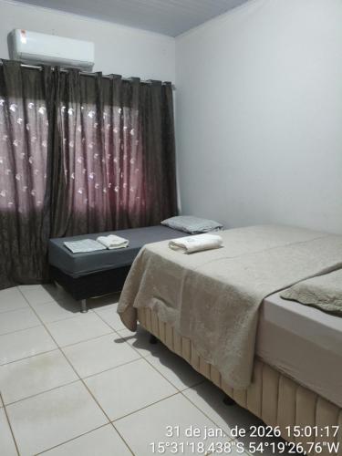 a room with two twin beds and a window at CASA FLORENÇA 2,2 km do Lago municipal in Primavera do Leste