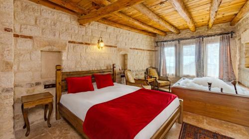 a bedroom with a large bed with red pillows at Zula Cave House in Ürgüp