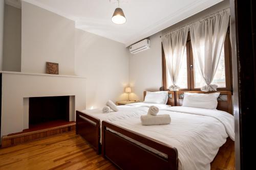 two beds in a bedroom with a fireplace at Mikio Guest House in Kalabaka