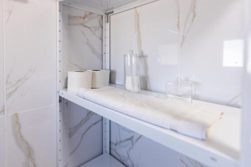 a bathroom with a shelf with towels and a mirror at Yellow House in Pilipets