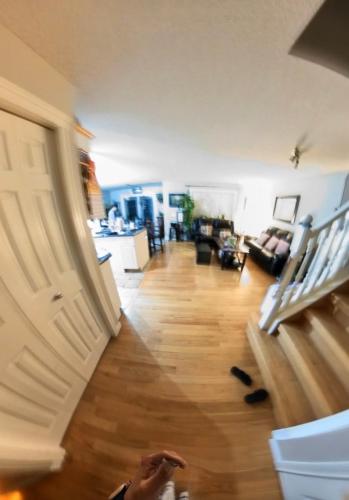 a living room with a door and a wooden floor at Jeli haus in Calgary