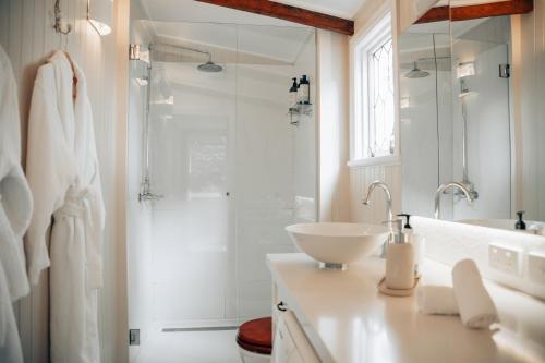 a white bathroom with a sink and a shower at Breathe Glenrock Gardens in Tenterfield