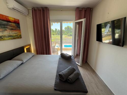 a bedroom with a bed with two towels on it at Sani Luxury Pool Villa in Sani Beach