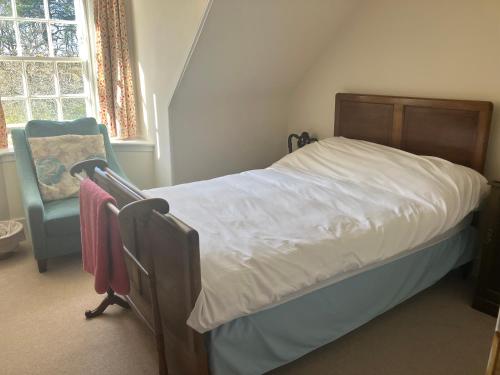 a bedroom with a bed and a chair and a window at Berryhill West Wing- 3 bedroom - 2 bathroom - Self Catering - Sleeps 4 - Dogs Welcome - Off-road Parking - Suit Contractors - Shooting Parties - Peterhead 1 mile - Newly Refurbished - Shed - Yard -Drying Room available in Peterhead