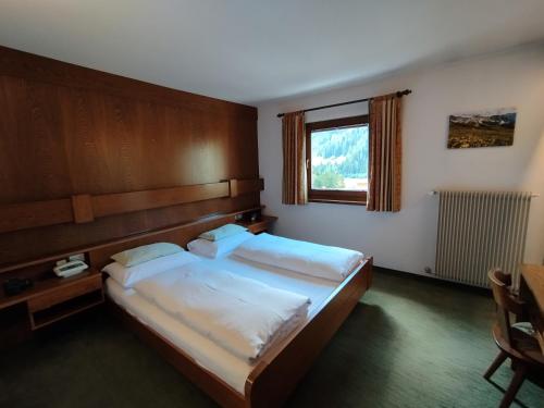 a bedroom with a large bed and a window at Villa Luise in Ortisei