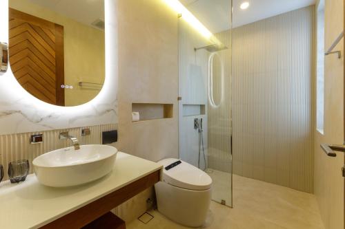 a bathroom with a sink and a toilet and a mirror at Luxe & Privacy Orchard Villas Pasak 4BR in Laguna Phuket