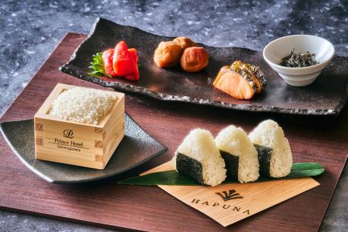 a table with two plates of sushi and a box at Shinagawa Prince Hotel in Tokyo