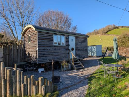 a tiny house in a yard next to a fence at Steam and Stars Luxury Glamping in Williton