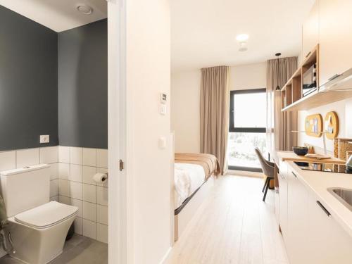 a bedroom with a bed and a bathroom with a sink at Canvas Sabadell Llac in Sabadell