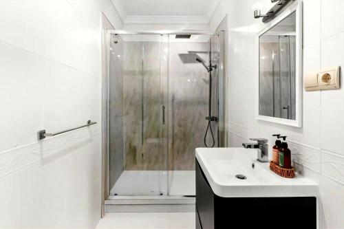 a white bathroom with a shower and a sink at Montaña Mimosa B&B in Alhaurín el Grande