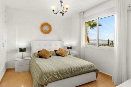 a white bedroom with a bed and a window at Montaña Mimosa B&B in Alhaurín el Grande
