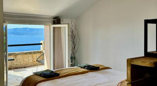 a bedroom with a bed and a view of the ocean at Fianca l'Osso in Belvédère