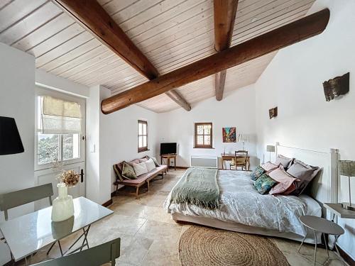 a bedroom with a bed and a desk in a room at Clos des Cassis - Maison d'Hôtes in Villeneuve