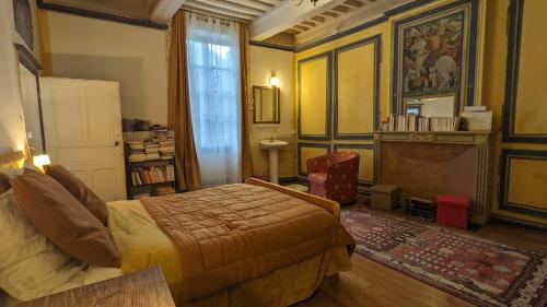a bedroom with a bed and a fireplace at Maison Romane 1136 in Cluny