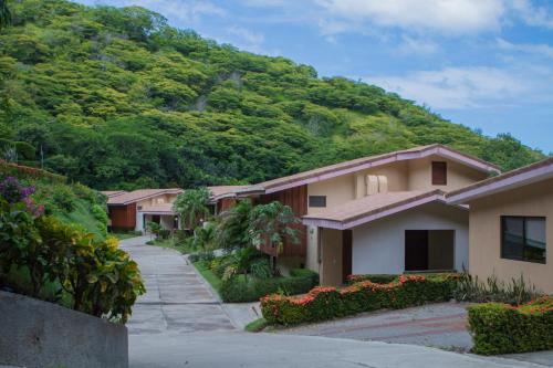 a row of houses in front of a mountain at Bahia Pez Vela Resort in Ocotal