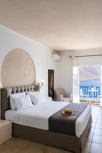 a bedroom with a large bed and a balcony at Aegialis Hotel & Spa in Aegiali
