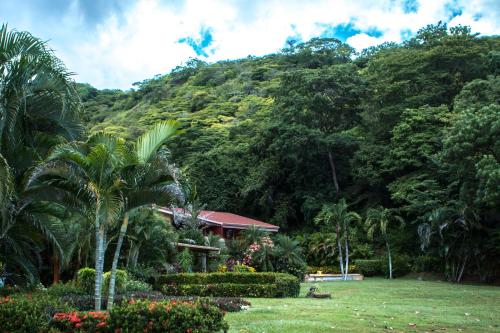 a house in front of a mountain with trees at Bahia Pez Vela Resort in Ocotal