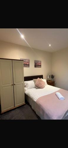 a bedroom with two beds and a cabinet at 36 flat 1 - Room 2 in Swansea